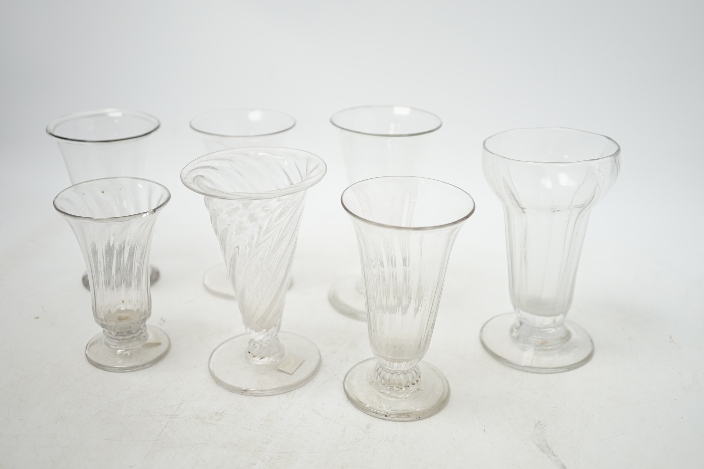 Seven 18th century jelly glasses, four with ribbed bowls, tallest 11.5cm. Condition - fair to good, chip to the rim of one and faults in the blowing.